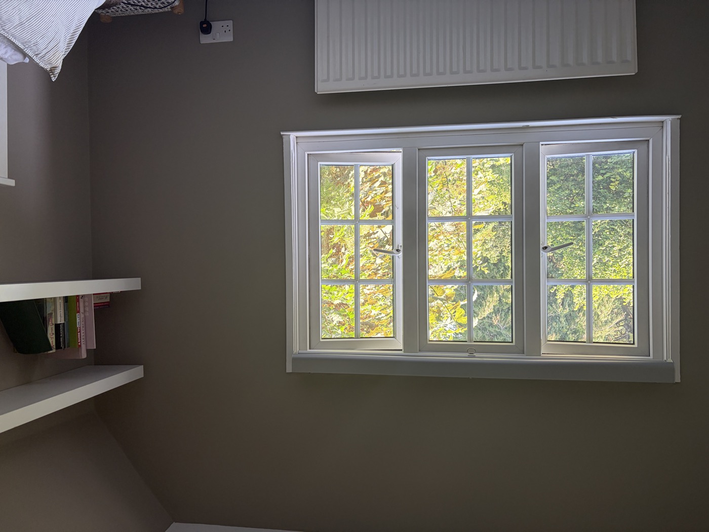 Bedroom with garden-view window — freshly painted walls