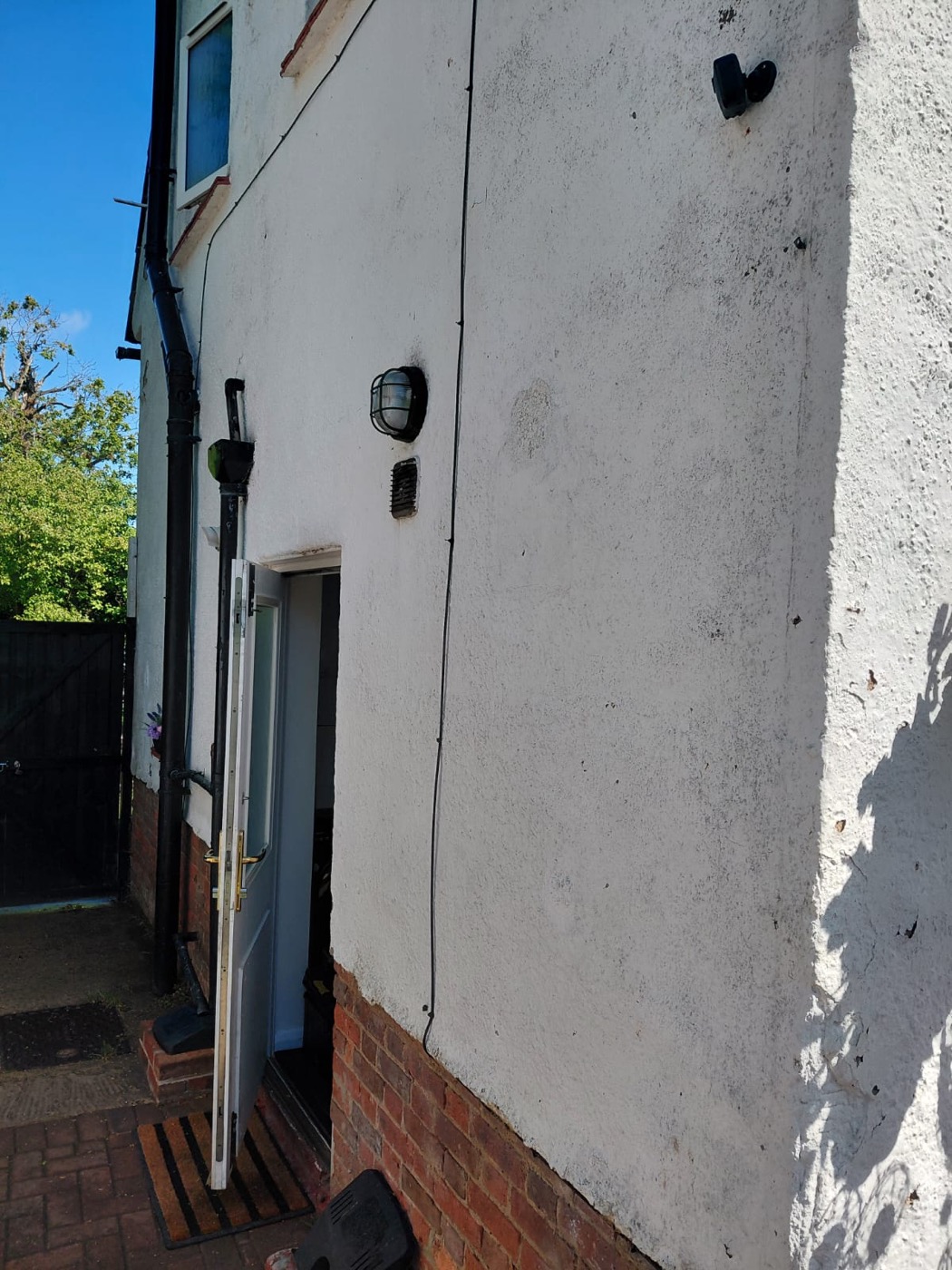 Side elevation showing patchy, deteriorating render