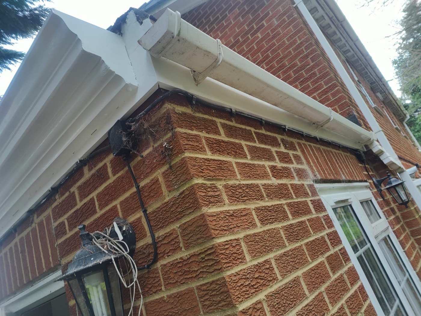 New white uPVC guttering installed on brick house — completed