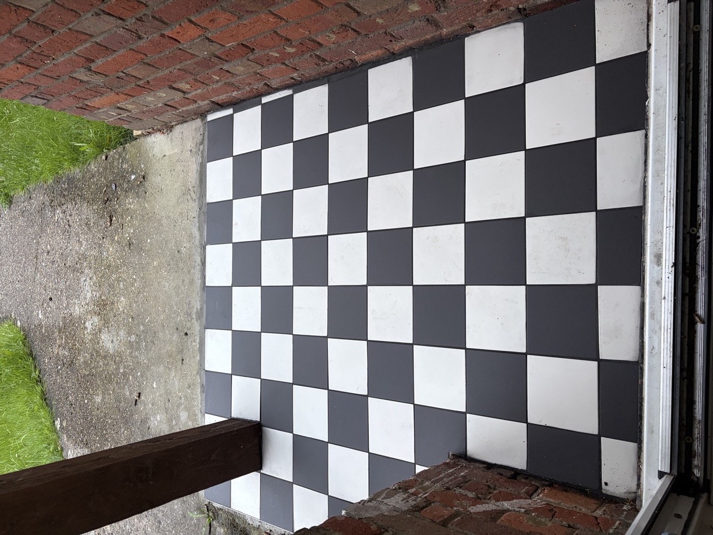 Completed black and white checkerboard porch floor — viewed from doorway