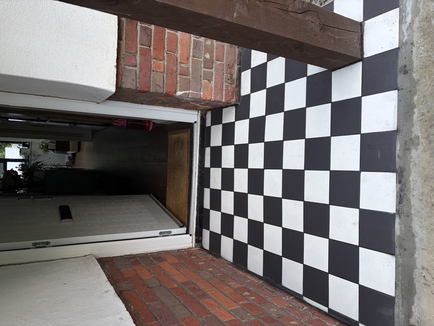 Completed checkerboard porch tiles — entrance with door